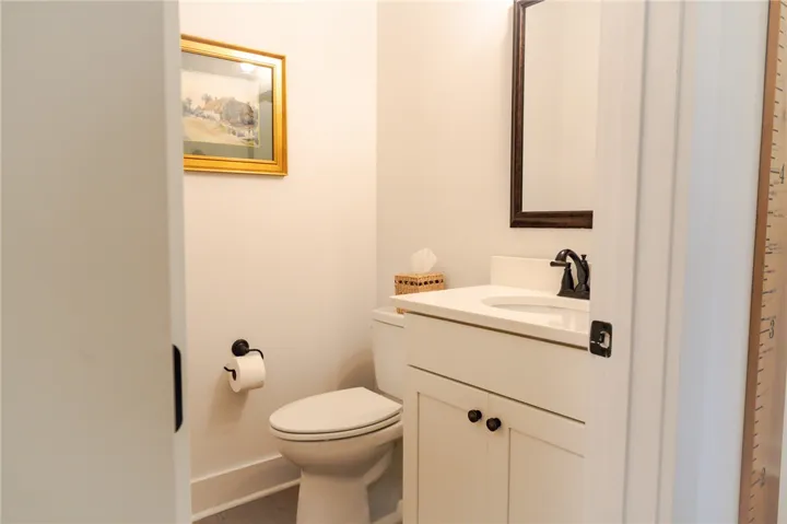 A well-appointed powder room features a classic pedestal sink and ample vanity storage.