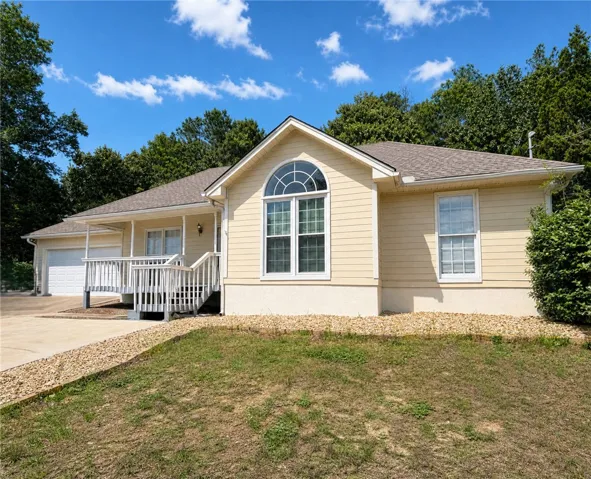 A welcoming front porch leads to a charming residence with a convenient attached garage.