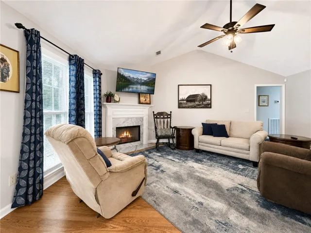 A comforting living space features a cozy fireplace and rich hardwood flooring.