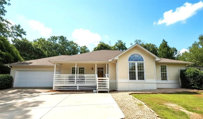 A welcoming facade with a classic porch and convenient garage access.