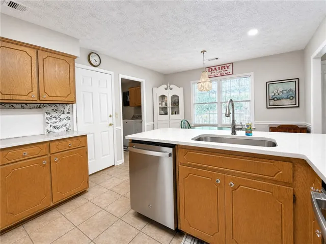 A functional kitchen boasts ample counter space, a large sink, and well-maintained cabinetry.