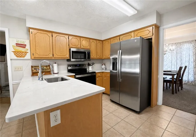 An inviting kitchen with light wood cabinetry and crisp white countertops is ready for culinary adventures.