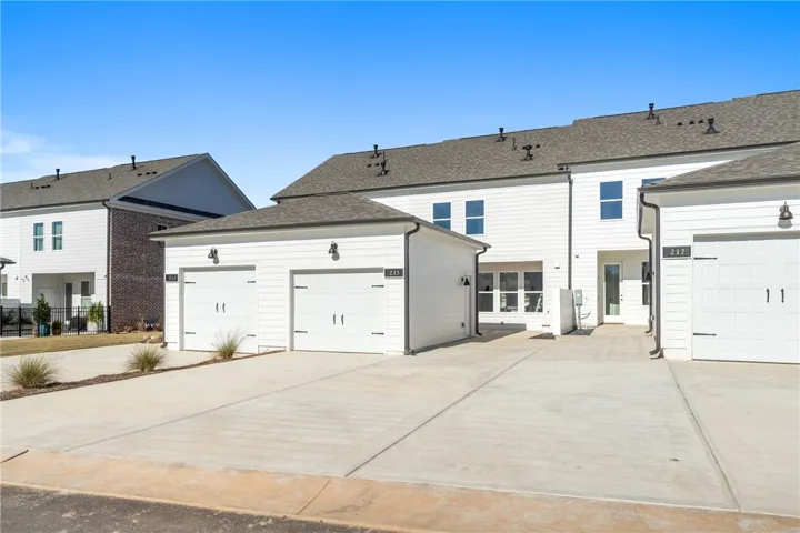 Clean lines and bright facades define this modern townhome community with individual garages and ample driveway space. Photos are not of subject property. Photos are of the same floorplan of a completed home.