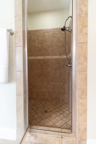 Step into this shower with a tile surround and floor, offering a refreshing start to your day.