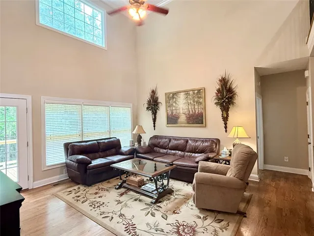 A spacious, naturally illuminated living room boasts high ceilings and hardwood flooring.