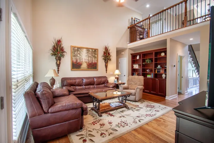 A spacious living area features high ceilings and polished hardwood flooring, ideal for relaxation and entertaining.