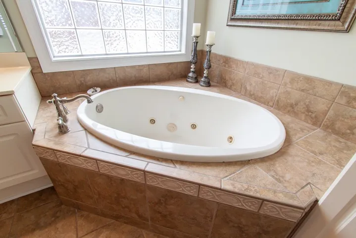 An inviting jetted tub with tiled surround offers a perfect spot for relaxation.