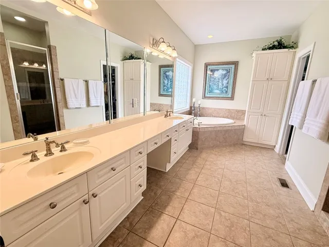 Indulge in a primary bathroom featuring a generous vanity, dual sinks, and a large jetted soaking tub.