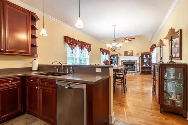 An open concept design seamlessly connects the kitchen and living space, anchored by a prominent stone fireplace.