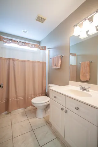 Functional full bathroom featuring a convenient vanity and tiled flooring.
