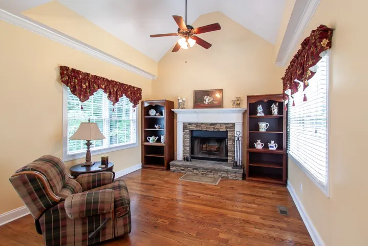 The keeping room is located just off the kitchen. Warm hardwood floors complement a cozy fireplace, creating an inviting gathering space.