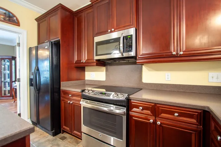 A well-appointed kitchen features rich cabinetry, practical countertops, and modern stainless steel appliances.