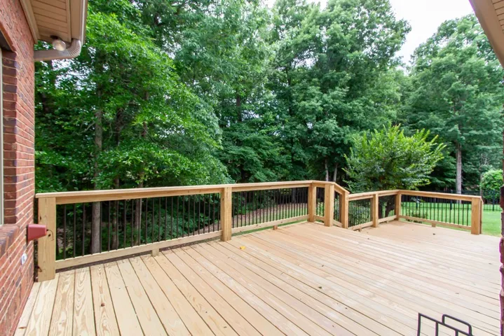 Enjoy outdoor living on this spacious deck with lush, verdant tree views.
