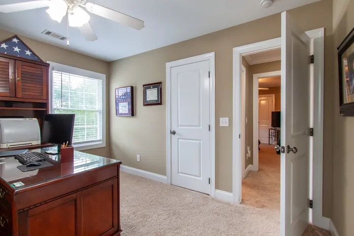 A quiet office space offers abundant natural light and soft carpet for a comfortable work environment.