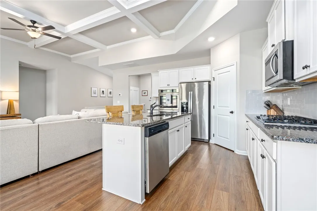 An open-concept design with hardwood floors unifies the kitchen and living areas.