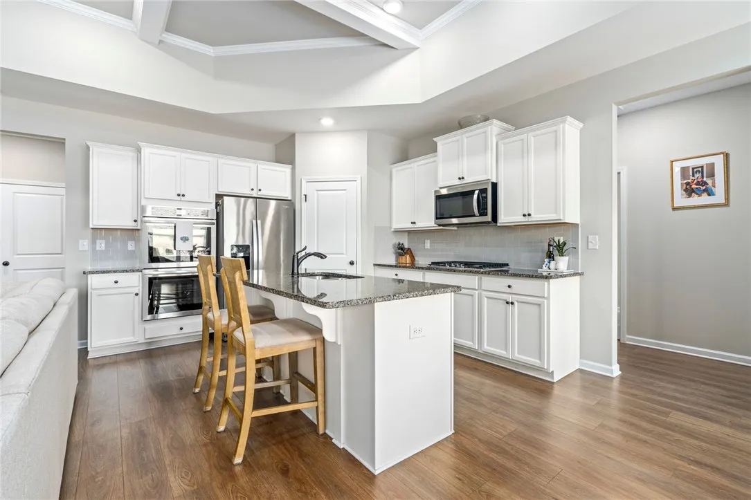 A well-appointed kitchen features a large central island and vaulted ceilings.