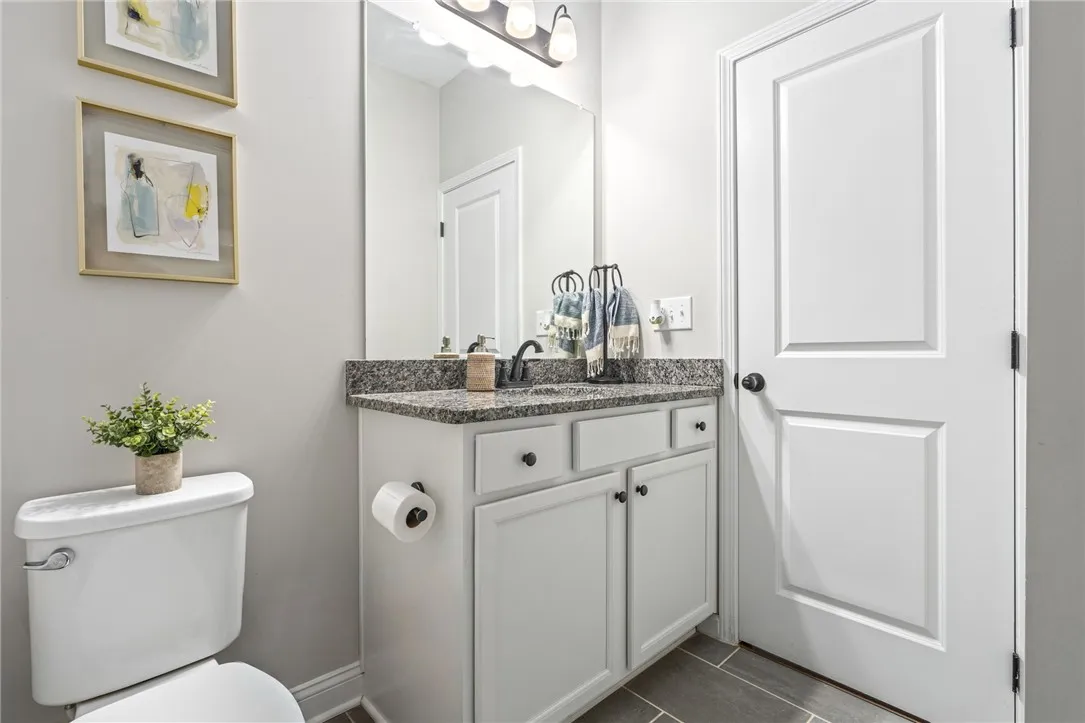 Granite counters and a clean, light vanity create a fresh and functional bathroom.