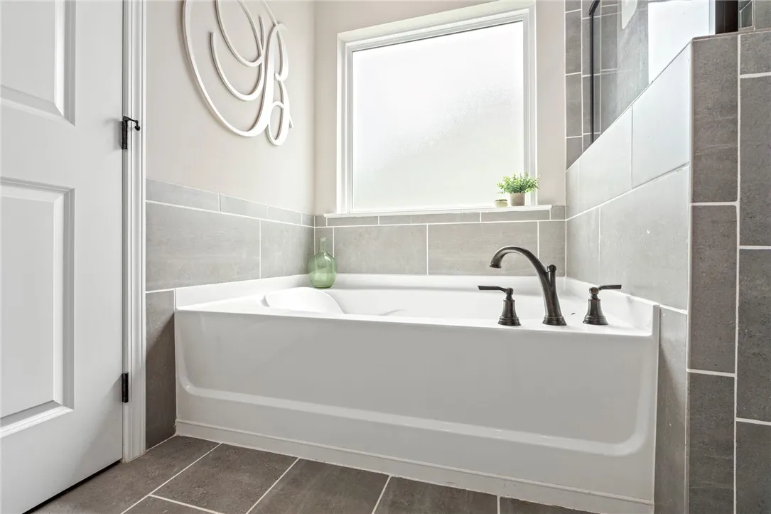 Indulge in a tranquil soak within this well-appointed bathroom featuring a deep tub and elegant fixtures.