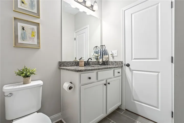 Granite counters and a clean, light vanity create a fresh and functional bathroom.