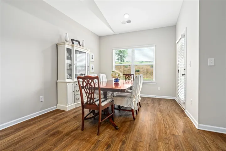 Elegant hardwood flooring enhances this dedicated dining space with ample natural light.