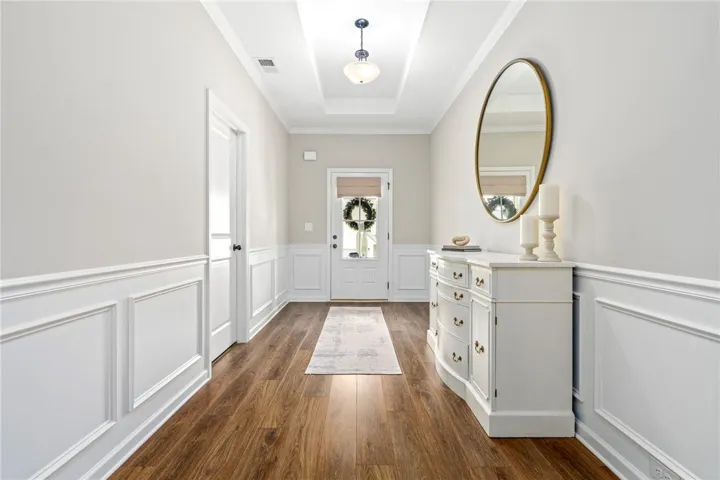 A graceful entry with warm wood flooring and classic wainscoting welcomes all who enter.
