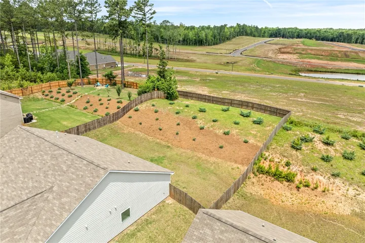 A spacious backyard provides ample green space, bordered by a privacy fence, ready for personalized landscaping touches.