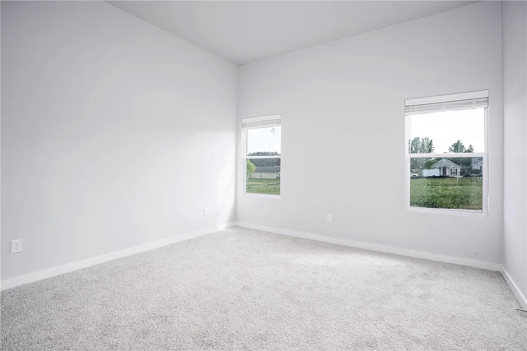 A spacious and pristine interior, ready for personalization, offers views of the surrounding neighborhood through two well-placed windows.