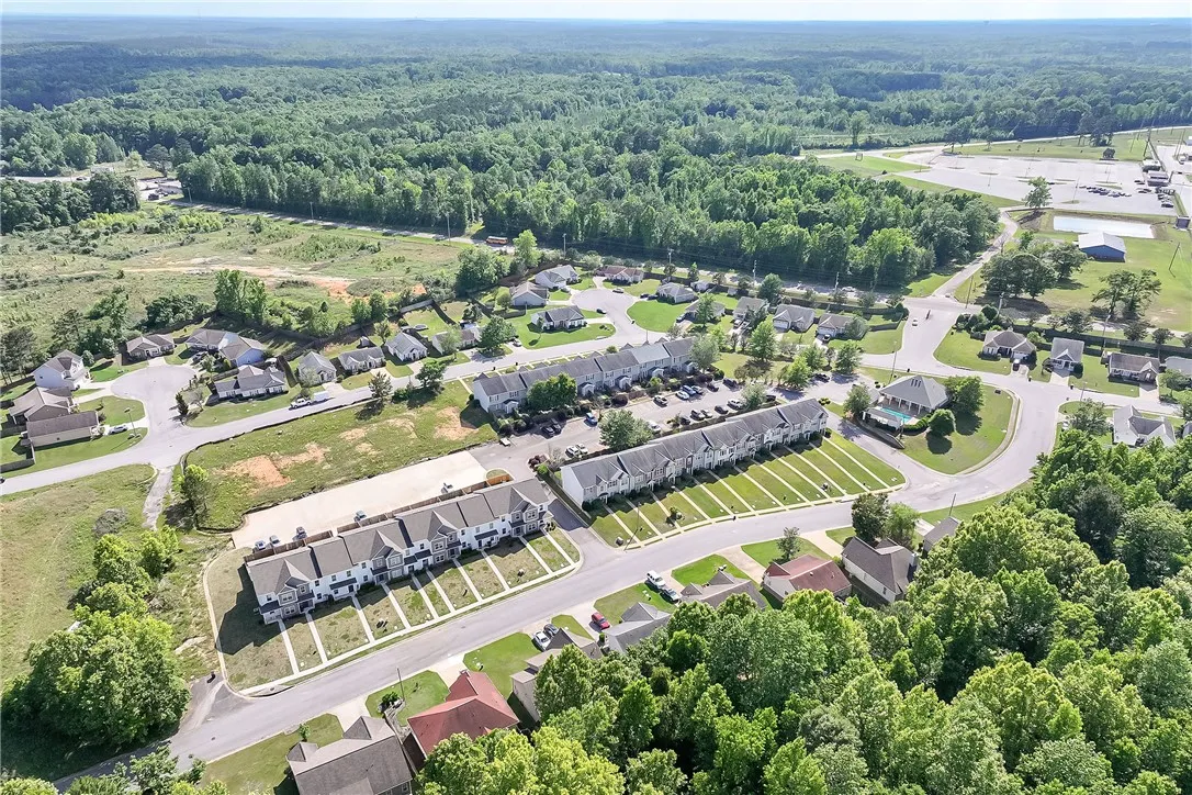 An aerial perspective reveals a charming residential community nestled amongst lush green woodlands.