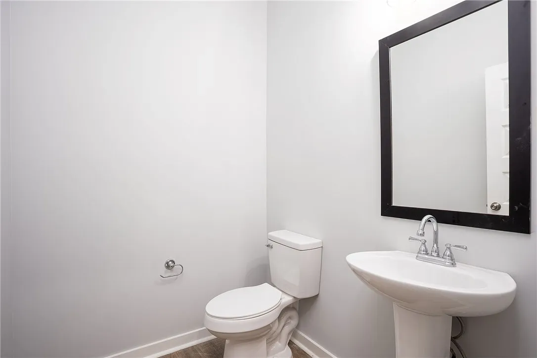 A well-appointed lavatory, featuring a pedestal sink and contemporary mirror.