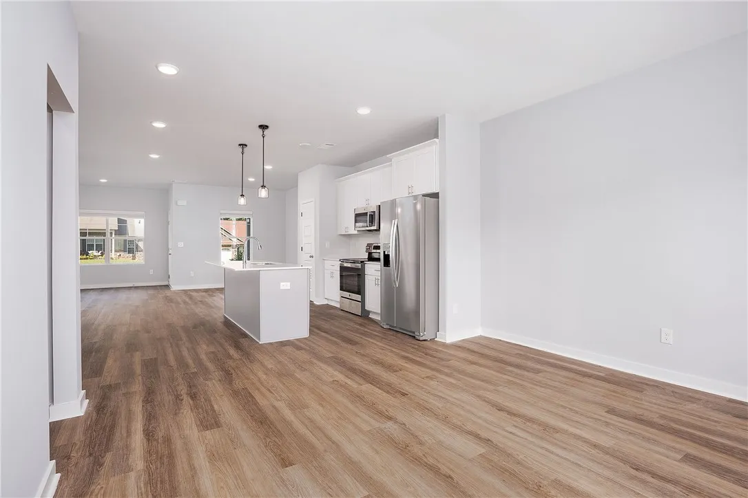 A contemporary open-concept layout unites kitchen and living areas, highlighted by recessed lighting.
