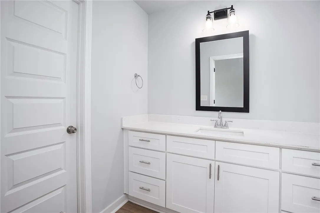 A well-appointed vanity with a modern sink and sleek white cabinetry defines this primary bathroom.
