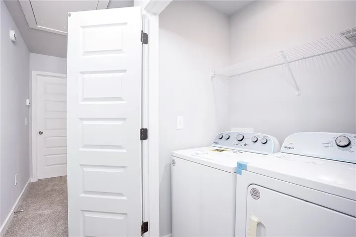 Functional laundry space featuring modern appliances and convenient wire shelving for storage.