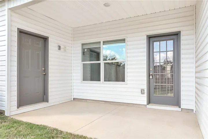 A modest concrete patio provides direct access to the interior and a storage area, framed by durable siding.