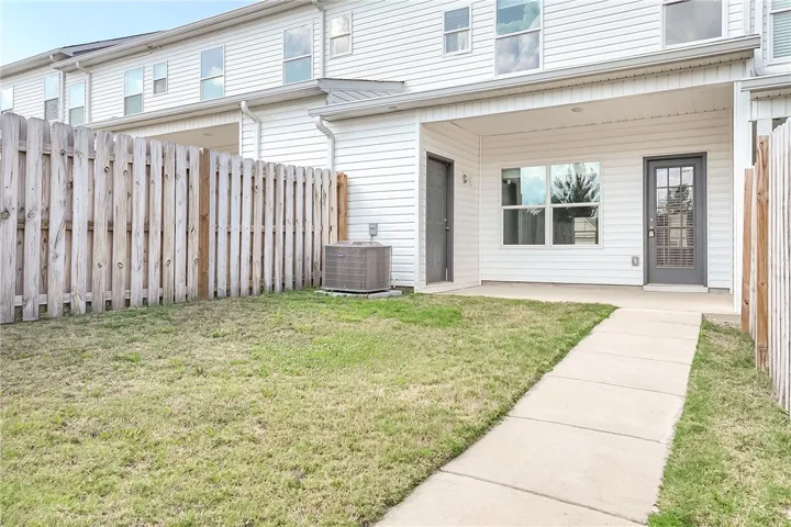 A private backyard oasis with a convenient concrete path leading to a covered patio area.