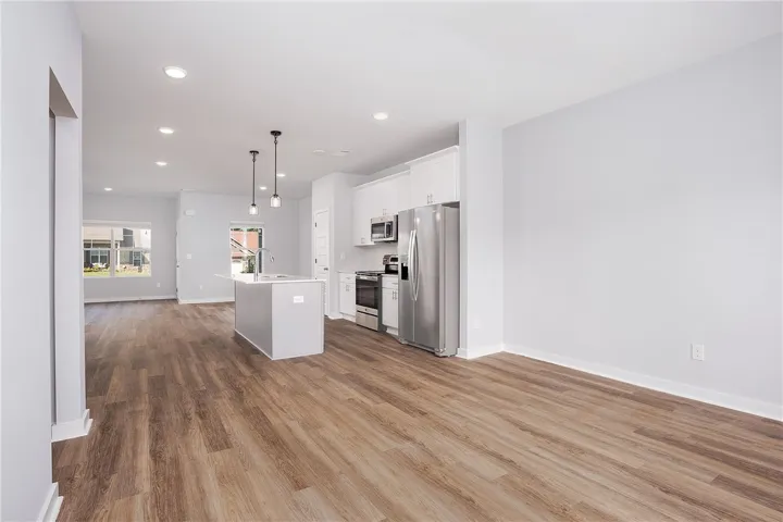 A contemporary open-concept layout unites kitchen and living areas, highlighted by recessed lighting.