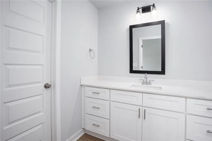 A well-appointed vanity with a modern sink and sleek white cabinetry defines this primary bathroom.