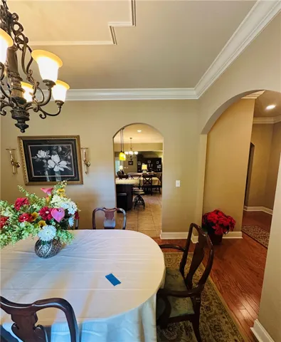 Elegant crown molding and recessed ceiling details define this inviting dining area, leading to an open-plan kitchen.