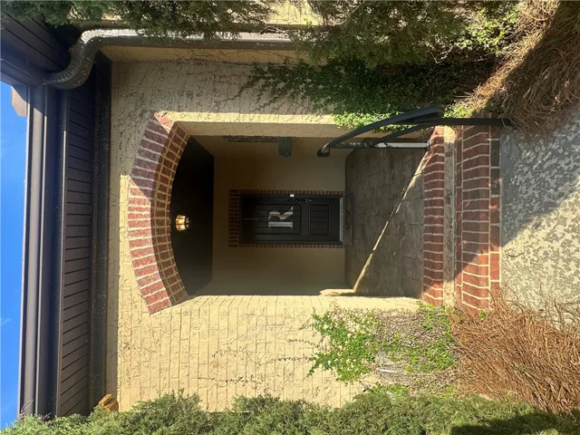 An inviting entry framed by a brick archway awaits, hinting at the home's unique character.