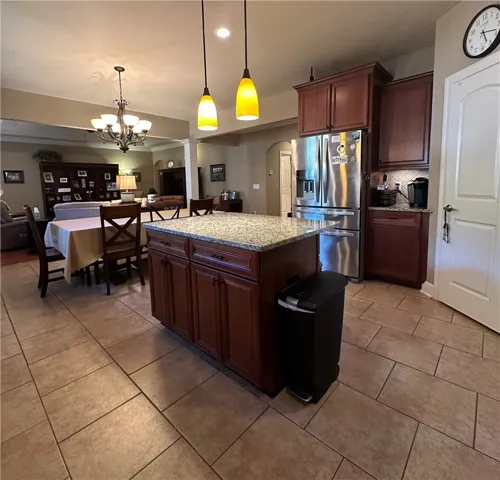 An inviting open-concept kitchen and dining area feature a central island and contemporary lighting.