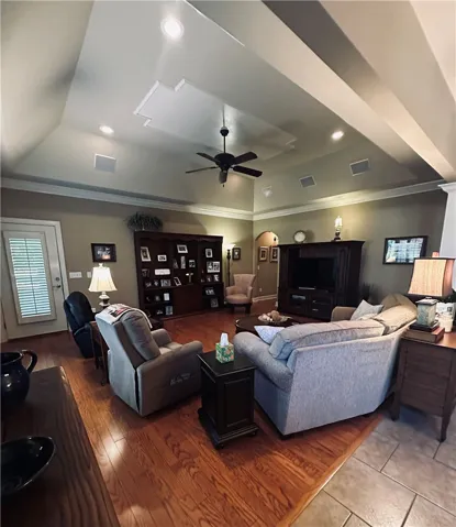 Recessed lighting illuminates this inviting living space, showcasing rich hardwood floors.