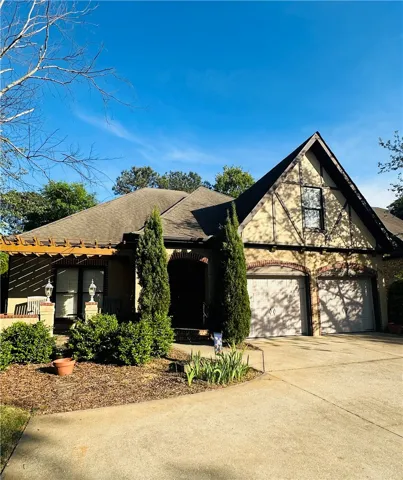 A charming Tudor-style home offers a picturesque façade and a welcoming front entrance.