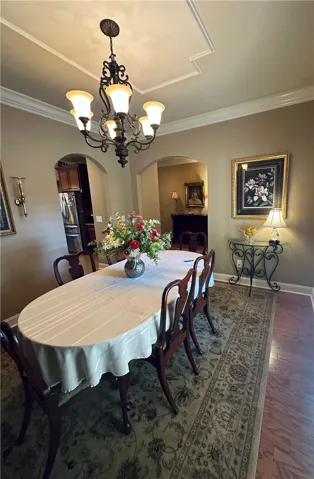 Elegant dining space, perfect for entertaining, with archways and warm wood flooring.