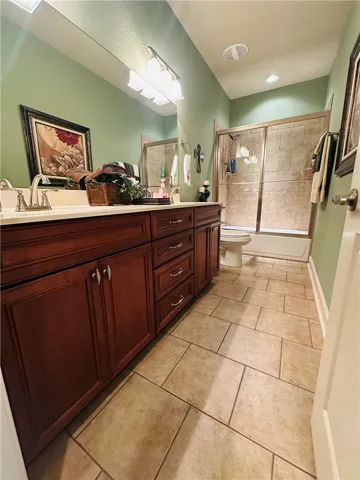 Functional bathroom features a dual vanity and a tile-enclosed shower with sliding glass doors.
