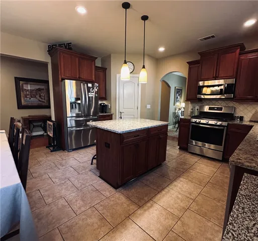 A warm, inviting kitchen with a central island and rich cabinetry for culinary creations.