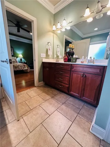 Dual vanities with rich cabinetry and ample lighting elevate this bathroom's functionality.