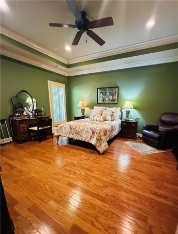 Hardwood flooring extends through this naturally illuminated primary bedroom, offering both comfort and enduring style.