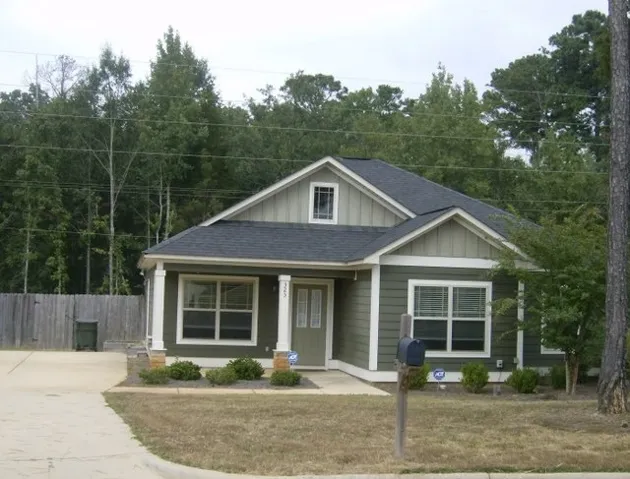 A charming single-story residence with a welcoming front entrance and well-kept landscaping awaits.