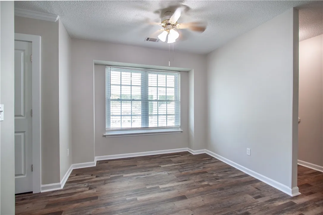 Hardwood-style flooring and a window with blinds define this inviting interior space.