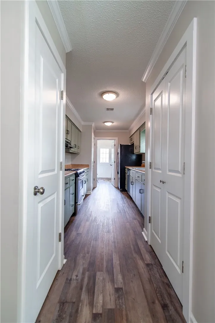 A well-appointed galley kitchen featuring hardwood flooring and ample cabinetry.