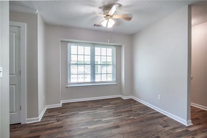 Hardwood-style flooring and a window with blinds define this inviting interior space.